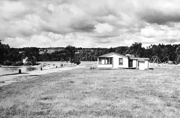 Photo d’archives en noir et blanc de la plage et d’un chalet aux débuts du quartier
